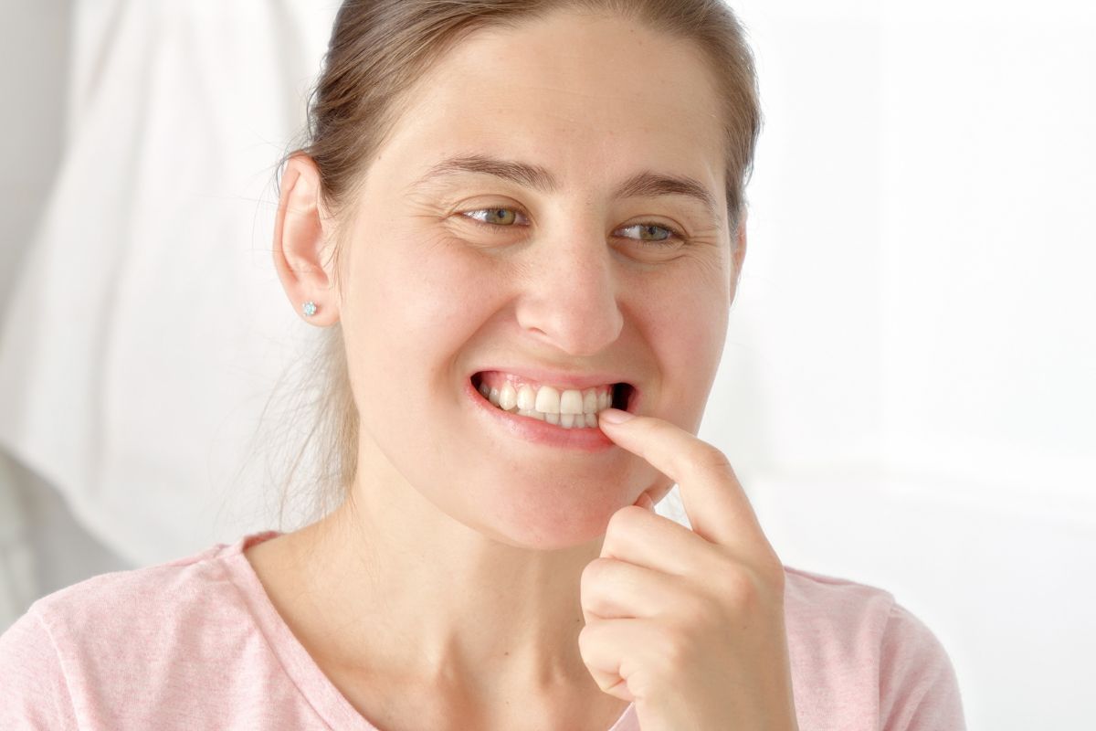 Woman checking her gums for oral health concerns – Gum Disease Treatment in Colorado Springs
